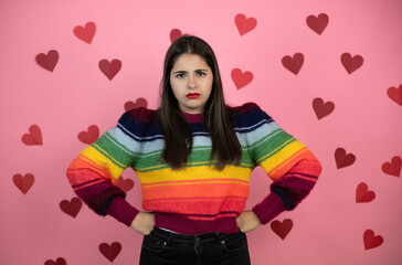 Young beautiful woman over pink background with harts skeptic and nervous, disapproving expression...