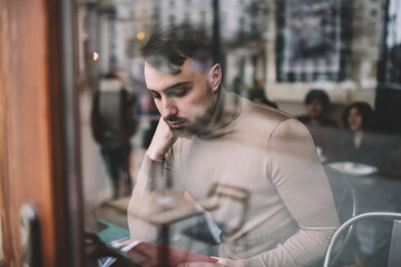 Focused man reading book in cafe