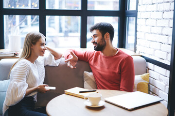 Positive guy and lady discussing plans in cafe