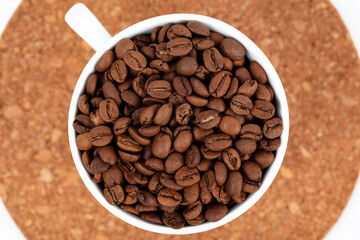 A cup of coffee beans isolated on a white background.
