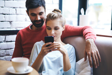 Couple using smartphone while resting in cafe