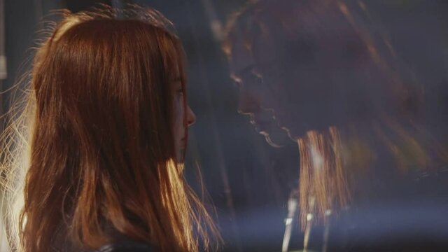 Tear-stained young woman sadly looks&nbsp;out&nbsp;the window