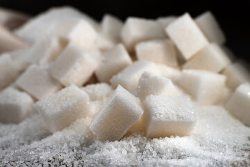Pieces of refined sugar on a dark background. Sugar is scattered on the burlap