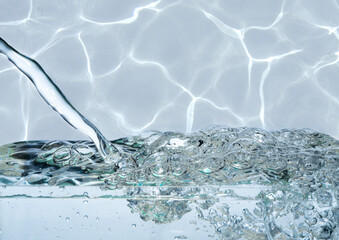 A clear fresh stream falls on a wavy water surface with a lot of splashes and bubbles, drowing...