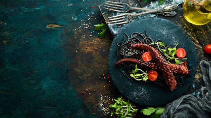 Octopus tentacles baked in garlic sauce and black pasta with cuttlefish ink. Luxury restaurant...