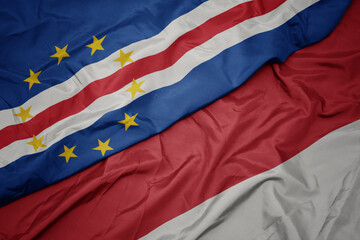 waving colorful flag of indonesia and national flag of cape verde.