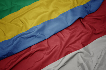waving colorful flag of indonesia and national flag of gabon.