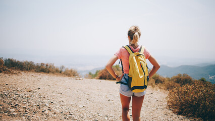 Traveling woman walking with backpack on road