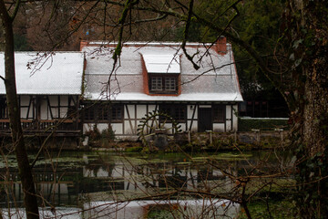 Fototapeta na wymiar Altes Fachwerkhaus an einem kleinen See mit Wasserrad