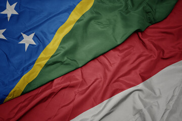 waving colorful flag of indonesia and national flag of Solomon Islands .