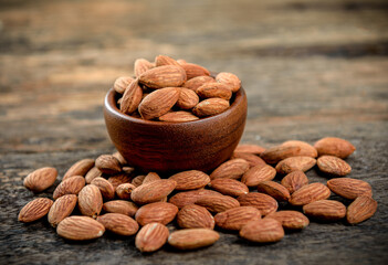 Almonds in wooden bowl on table.