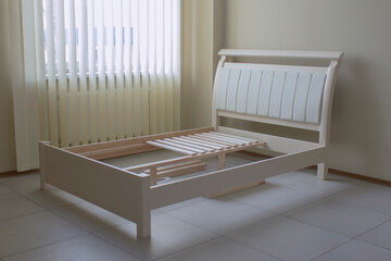 Fototapeta na wymiar white wooden bed with a soft back