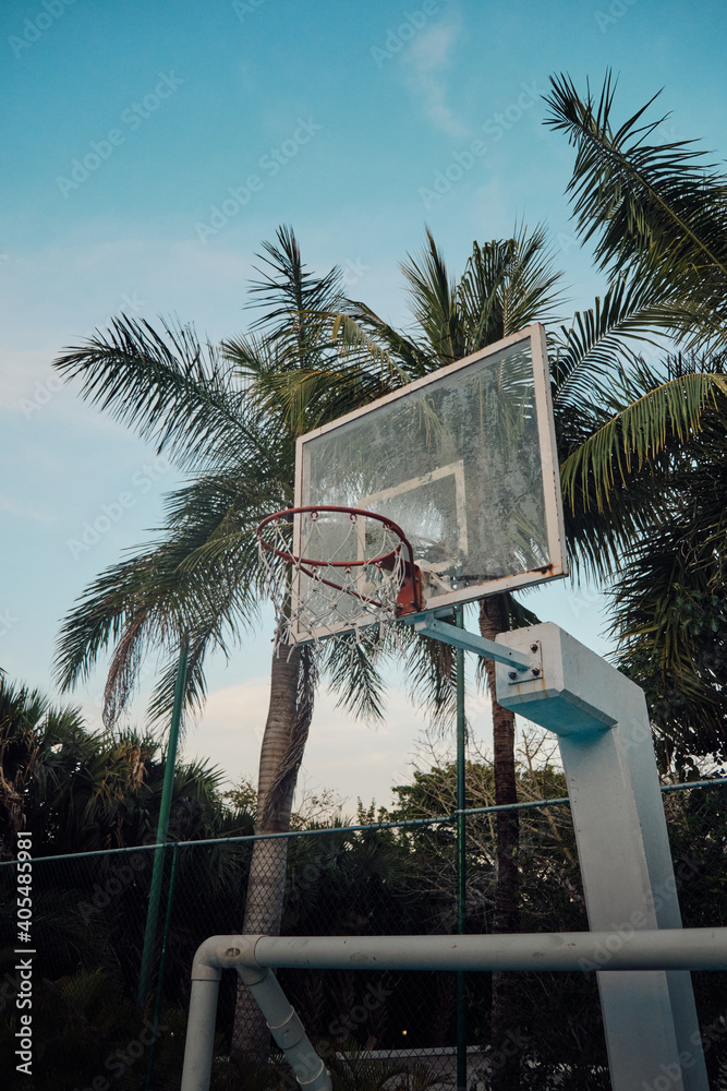 Sticker Vertical shot of a basketball rack in a court surrounded by tre