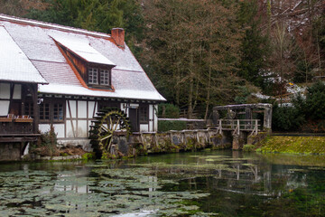 Obraz premium Altes Fachwerkhaus mit einem Wasserrad an einem See