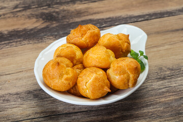 Sweet tasty profiteroles heap in the bowl