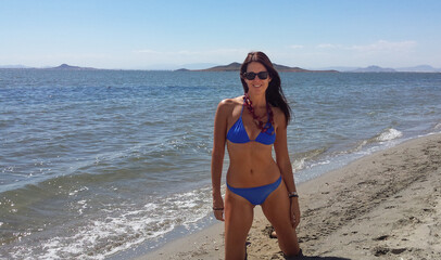 Young slim beautiful woman stay and posing in the sea or ocean waves