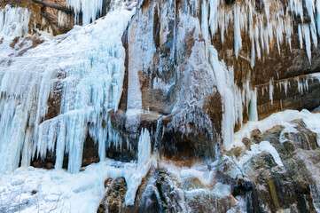 Fototapeta na wymiar A frozen waterfall with ice in a blue and white color in winter