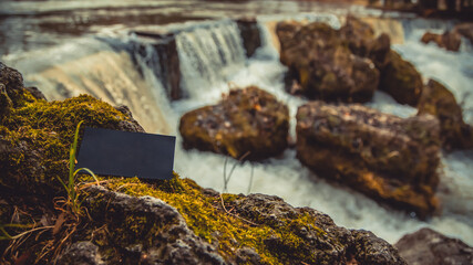 blank business card for your text and logo on the background of the Austrian mountain lake. black blank business card. black sheet of cardboard in hand and free standing