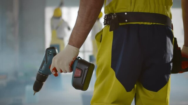 Close up of builder holding screwdriver working at construction site