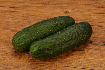 Green fresh cucumbers over background
