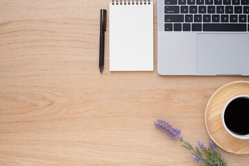 Top view above of Wooden office desk table with keyboard of laptop,  coffee cup and notebook with equipment office supplies. Business and finance concept. Workplace, Flat lay with blank copy space.