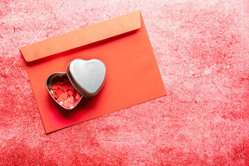 Valentine's day composition - candy hearts in gift box and red envelope on red stone background. Love romantic concept. Flat lay, top view, copy space.
