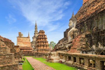 Fototapeta na wymiar Buddha statue and pagoda Wat Mahathat temple, Sukhothai Historical Park, Thailand