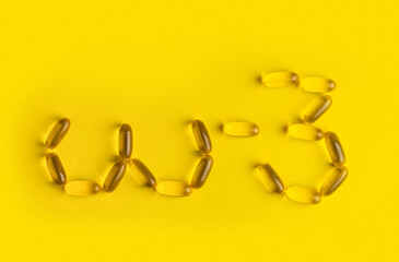 omega 3 gel capsules on yellow background