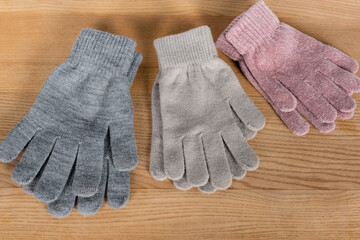 Top view of warm gloves on wooden surface
