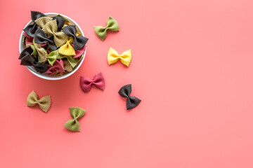 Coloured farfalle pasta in bowl, top view