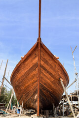 Frontal view of a wooden dhow (a traditional arabian sailing vessel) being constructed in Sur Dhow Factory. Sur, Oman.
