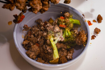 ceramic casserole of ground beef stir-fry with vegetables broccoli pepper and onion on a white base Cordoba Argentina