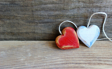 Two wooden hearts with texture and white rope isolated on old wooden background. Love and Valentine's Day concept. Retro classic Valentine Day cad. Close up