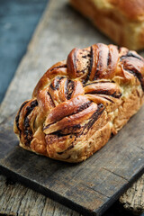 Sliced freshly baked mexican traditional pan de muerto with chocolate and cinnamon filling on a Oaxaca traditional barro negro pottery plate for the día de los muertos celebration on november 2nd
