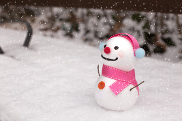 cute snowman standing on snowy field in winter.