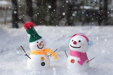 cute snowman standing on snowy field in winter.