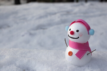 cute snowman standing on snowy field in winter.