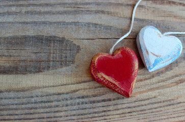 Two wooden hearts with texture and white rope isolated on old wooden background. Love and Valentine's Day concept. Retro classic Valentine Day cad. Close up