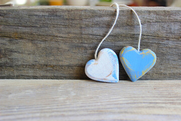 Two wooden hearts with texture and white rope isolated on old wooden background. Love and Valentine's Day concept. Retro classic Valentine Day cad. Close up