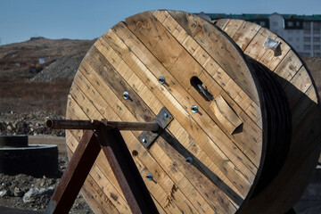 Wooden spool with black cable. Wooden spool.