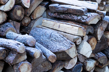 Pile of firewood covered with frost. Image with selected focus