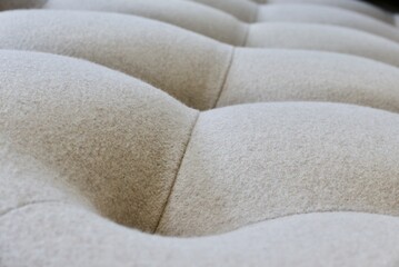 Fototapeta na wymiar Bedhead buttoned upholstery. Wool fabric rhythm and shapes explored.