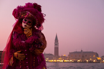 Venice, Italy - February 18, 2020: An unidentified woman in a carnival costume in front of Piazza San Marco, attends at the Carnival of Venice.