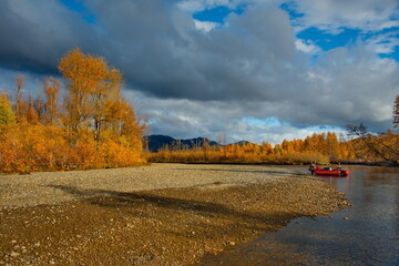 Russia. Far East, Magadan region. Picturesque autumn fishing from a boat on the tributaries of the...