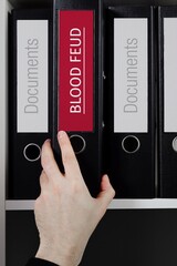 Blood Feud. Folder with label on the shelf of a lawyer. Red label with text in focus.