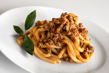 Plate of pici with wild boar ragout with bay leaves