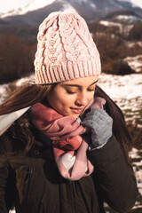 Young woman portrait on a winter landscape well wrapped up for cold