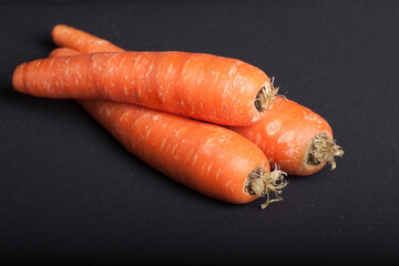 Three fresh carrots with black background