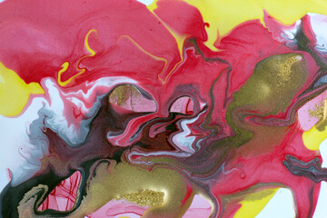 Pink, yellow and gold mixed inks marble background. Golden glitter texture.