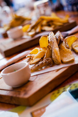 closeup of fries bravas fritas wedge potatoes with skin on wood and bowl of salsa cordoba argentina